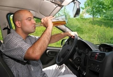 Foto de archivo-Fotolia: Un conductor bebe alcohol al volante de un vehículo