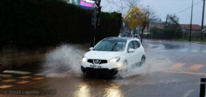 En la imagen un coche pasa por un charco en Cartes Problemas con el teléfono e Internet de Vodafone por las inundaciones